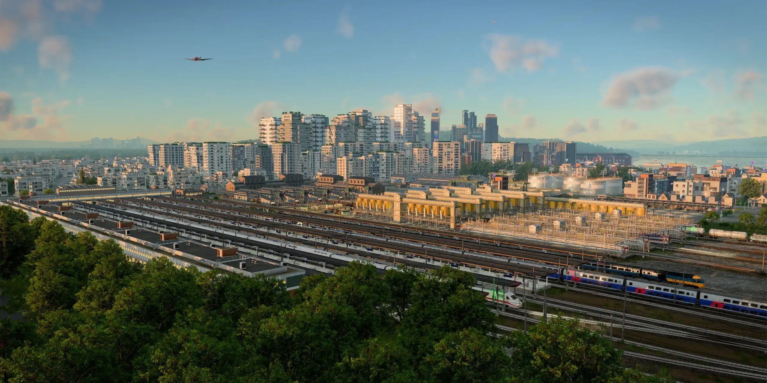 An aerial view of a dense city transport hub with rail lines, platforms, and trains.